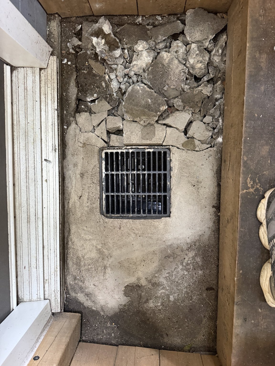 Existing concrete broken out around the drain