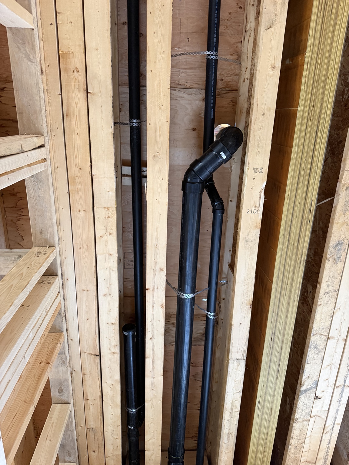 Drain and vent piping installed within exposed wall framing