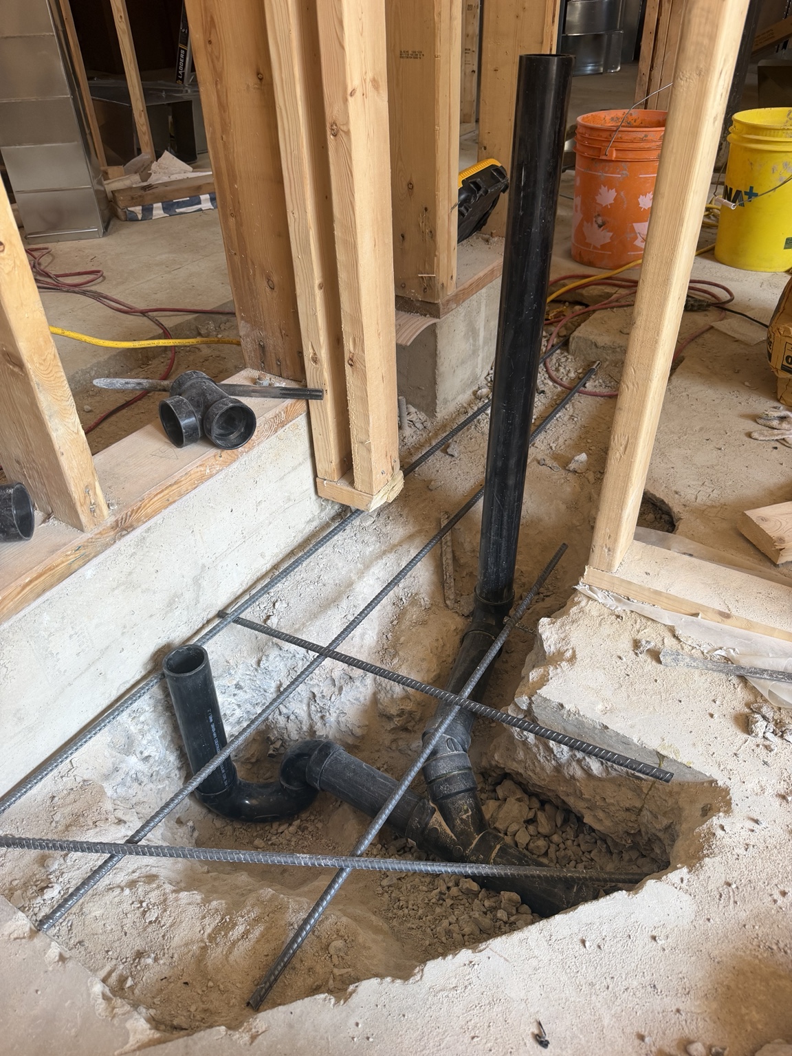 Shower drain rough-in before backfill and concrete restoration