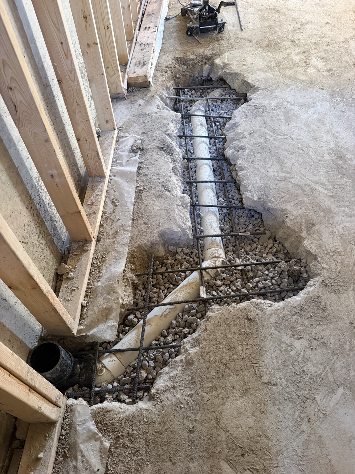 Drain trench with gravel and reinforcing bars before concrete